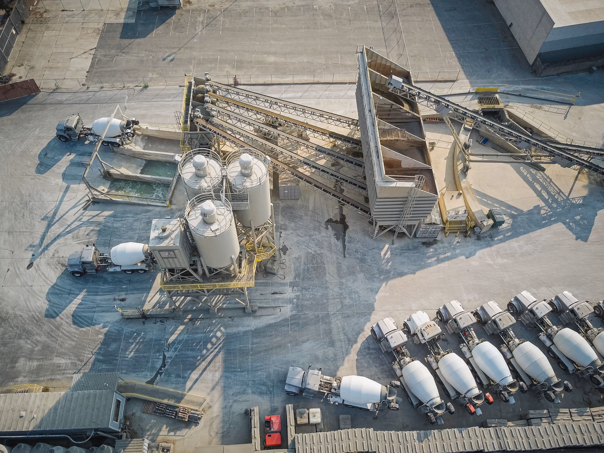 Vue aérienne d'une centrale à béton et de sa flotte de camions toupies